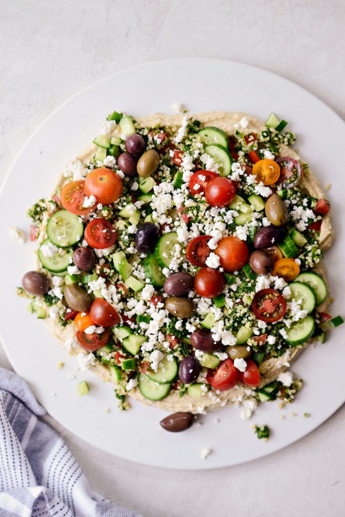 loaded hummus dip topped with tomatoes, feta and olives