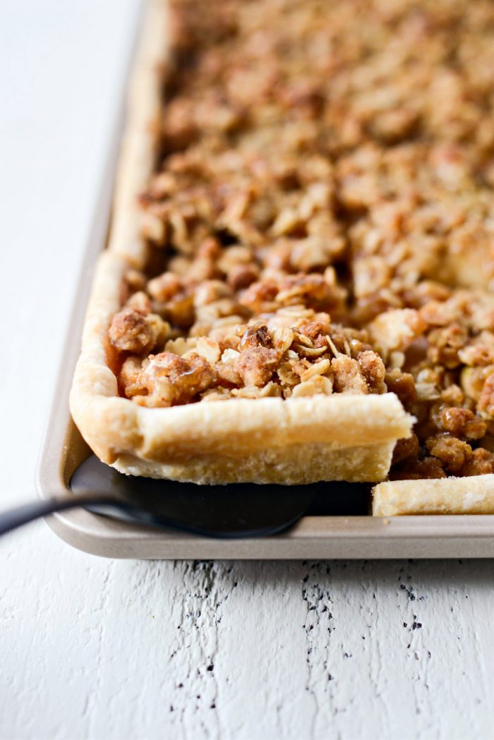 piece of Caramel Apple Slab Pie being dished on a black pie server.