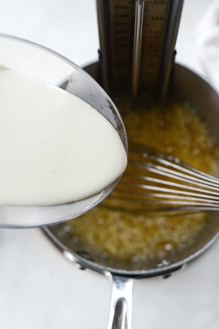 carefully pouring in heavy cream while stirring