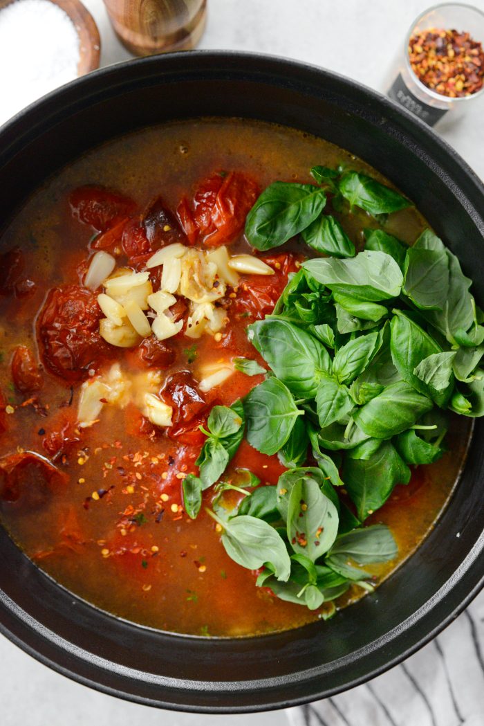 add in broth, canned tomatoes roasted garlic and basil