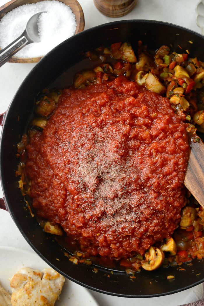 pour in crushed tomatoes and season with sugar, salt and pepper