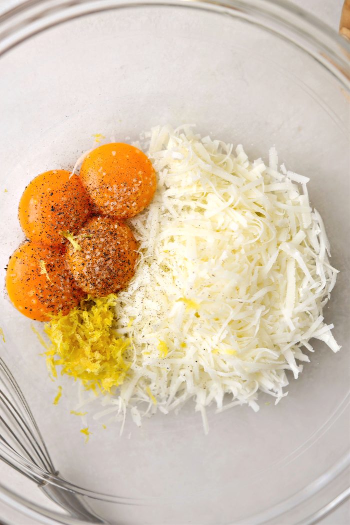 in a bowl add egg yolks, cheese, lemon zest, salt and pepper