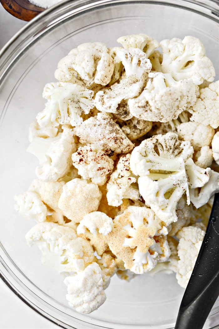 add cauliflower florets in bowl with bacon fat and seasonings